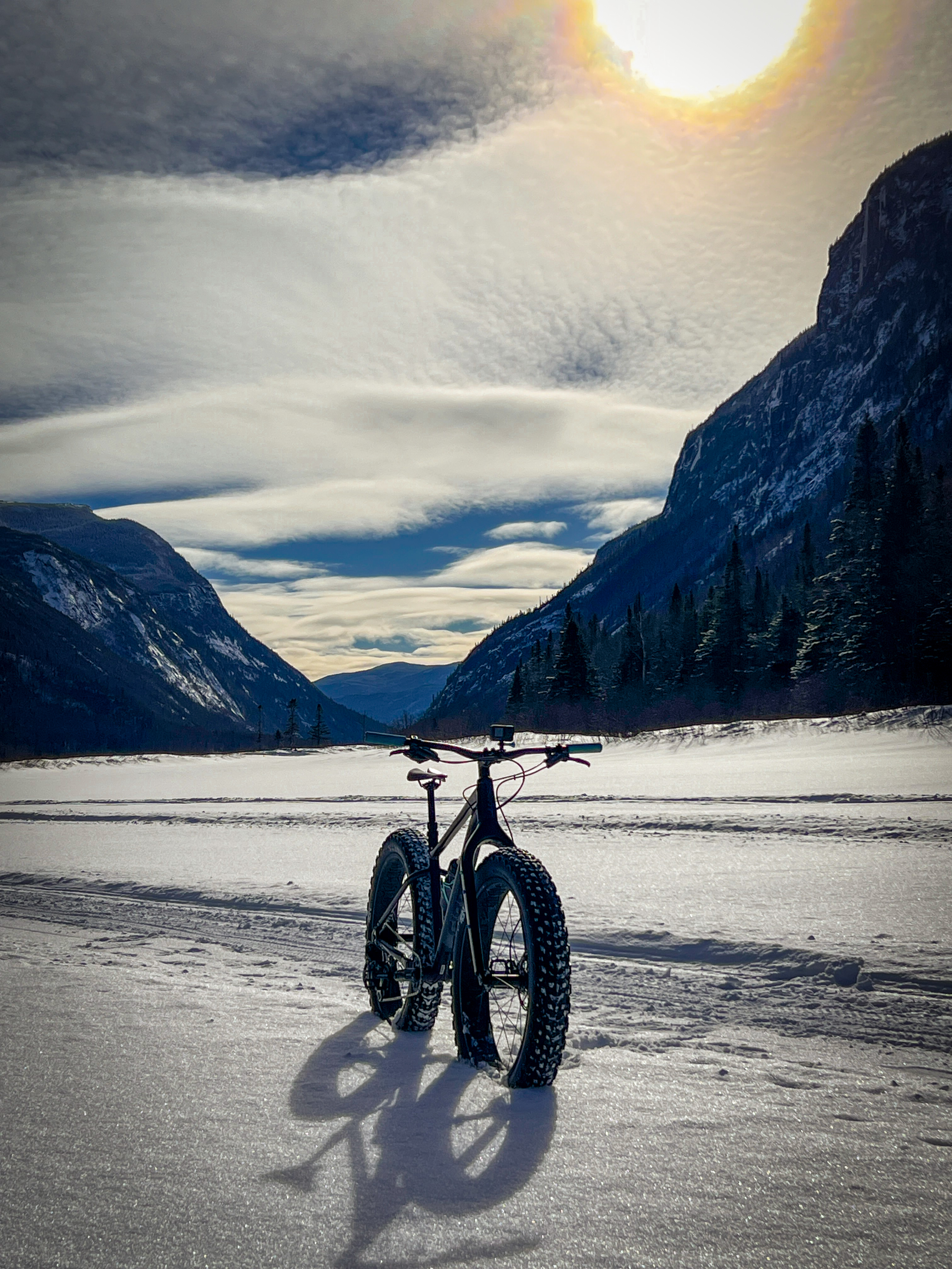 Fatbike sur un lac gelé, montagnes en arrière-plan